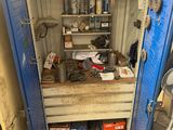 a blue metal cabinet with tools on it in a garage