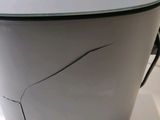 a gray trash can sitting on a white table