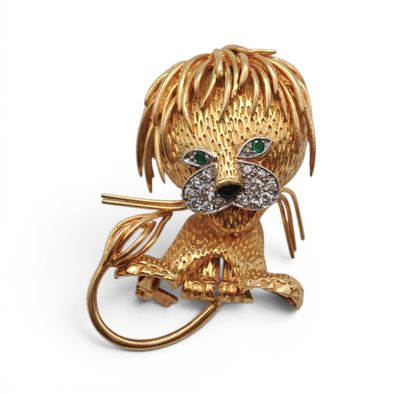 une image représentant une broche en forme de chien, en or et diamants, aux yeux verts