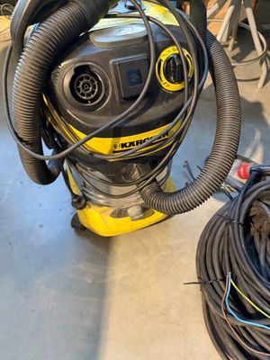 un aspirateur posé par terre à côté d'un enchevêtrement de fils