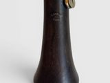 a wooden vase with a metal handle on a white surface