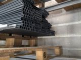 a stack of black pipes on a pallet in a warehouse