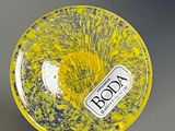 a yellow bowl with a label on it sitting on a table
