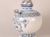 a blue and white vase with a lid on a table