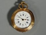 a gold pocket watch with roman numerals on the face