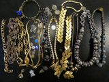 many different types of necklaces and bracelets on a table