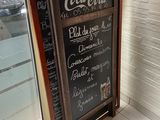 a chalk board with a menu written on it in front of a window