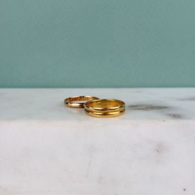 deux alliances en or posées sur une dalle de marbre