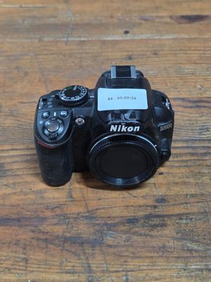 a camera sitting on a wooden table with a tag on it