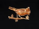 a gold plated bird sitting on top of a tree branch