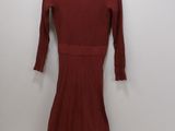 a red dress hanging on a hanger in front of a white wall