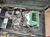 une boîte à outils contenant des outils, posée sur le sol