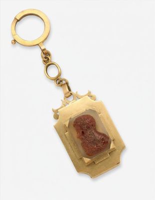 une image représentant un porte-clés en or orné du portrait d'une femme