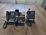 three phones sitting on a table with a cup of coffee