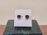 boucles d'oreilles en améthorate posées sur un bloc de marbre