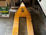 un chariot élévateur rangé dans un garage avec d'autres outils