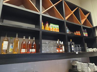 de nombreuses bouteilles et verres sur les étagères de la cuisine