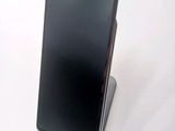 the back of a black cell phone sitting on top of a white surface