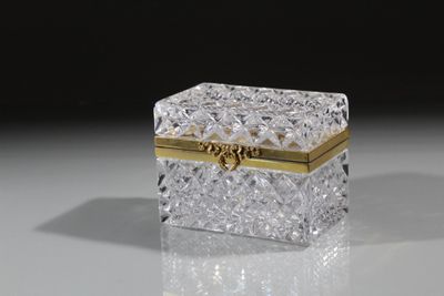boîte en cristal posée sur une surface réfléchissante avec un fond noir