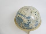 a blue and white globe on a stand on a white surface