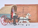 toy horse pulling a covered wagon with a woman in it