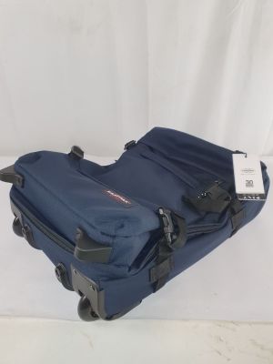 une valise bleue posée sur une surface blanche