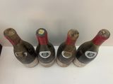 quatre bouteilles de vin sont alignées sur une table