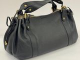 a black handbag with gold hardware on the handles
