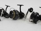 a couple of fishing reels sitting next to each other on a white surface