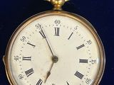 une montre de poche en or avec des chiffres romains sur le cadran