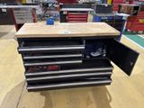 a workbench with drawers and tools on it in a garage