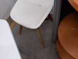 two white chairs and a table in a room