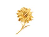 gold plated flower brooch with leaves on a white background