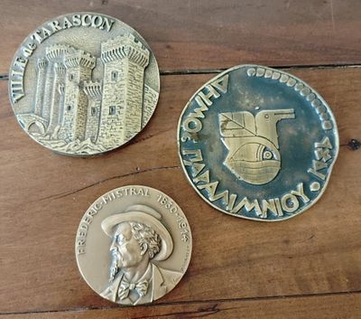 Trois pièces de monnaie sont posées les unes à côté des autres sur une table en bois.