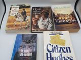 Plusieurs livres sont posés sur une table blanche, à côté d'une lampe