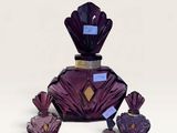 purple glass perfume bottle with purple crystals on a white surface