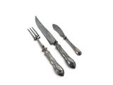 two forks and a knife on a white surface