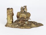 a gold statue of a man and a woman on a rock
