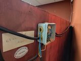 un boîtier muni de fils, placé dans un coin de la pièce