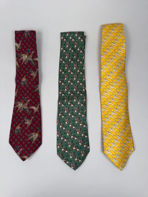 three ties are lined up in a row on a white surface
