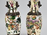 pair of chinese vases with floral designs on them on a gray background