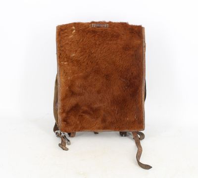 brown leather backpack with brown fur inside on a white background