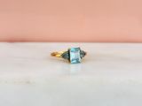 Gros plan sur une bague en or ornée d'une topaze bleue