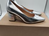 a pair of silver shoes sitting on top of a cardboard box