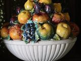 a white bowl filled with fruit on top of a table