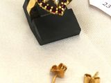 paire de boucles d'oreilles dorées ornées de grenats et d'un fil rouge