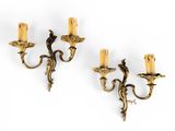a pair of brass wall sconces with candles on each side