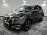une Nissan QX-V grise garée sur un sol à damier