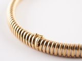 a close up of a gold necklace on a white surface