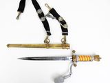 a sword with a gold handle and a black strap